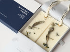 Close-up of Midnight Amber wax tablets with dried sage and rosemary in the gift box